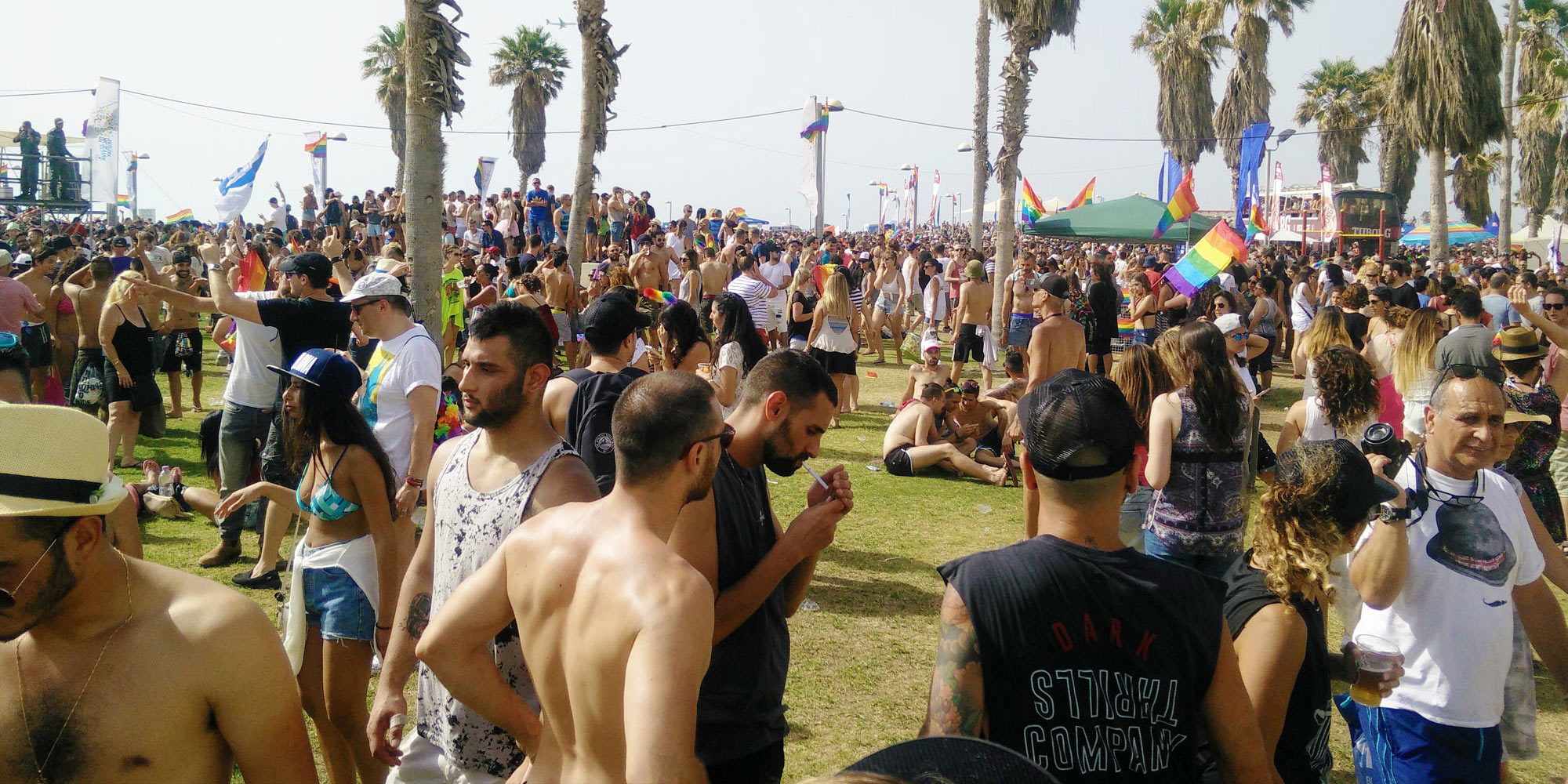thousands celebrate Tel Aviv Pride at Charles Clore Park, some with bare chest because of the heat